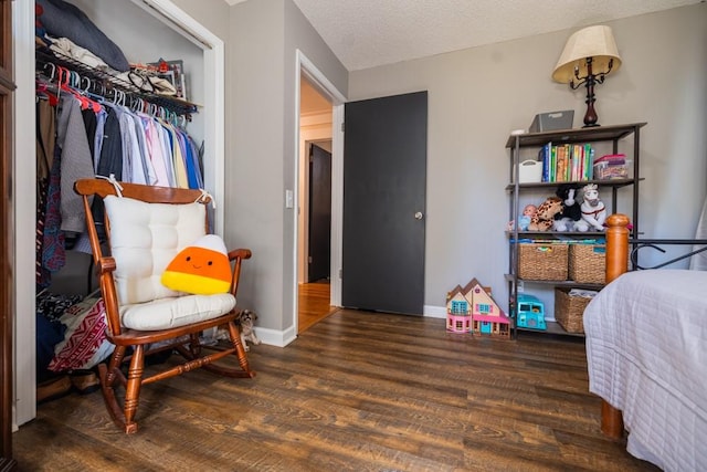 bedroom featuring a closet, dark hardwood / wood-style flooring, and a textured ceiling