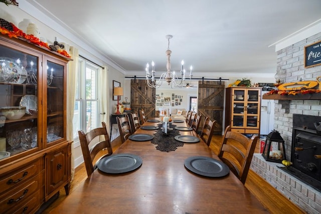 dining room featuring crown molding, hardwood / wood-style flooring, and a barn door