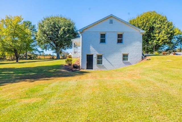 rear view of house featuring a yard