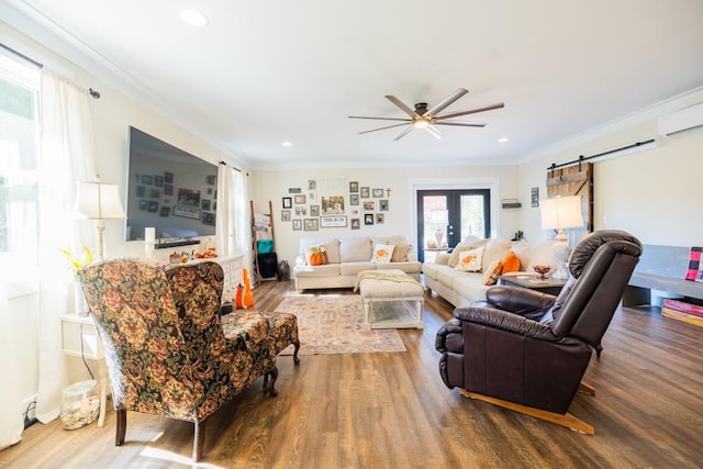 living room with hardwood / wood-style floors, ornamental molding, and a barn door