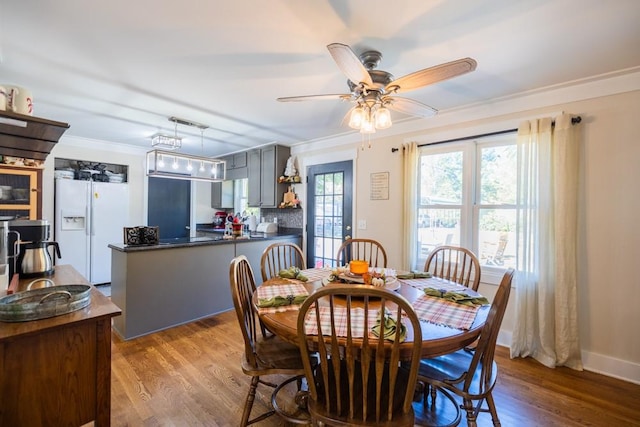 dining room featuring ceiling fan, ornamental molding, and light wood-type flooring