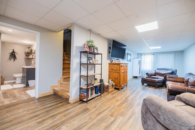 living room with wood-type flooring and a drop ceiling