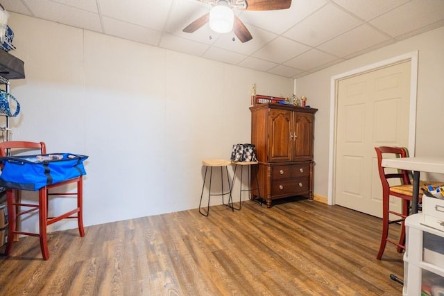 misc room featuring dark wood-type flooring, a paneled ceiling, and ceiling fan