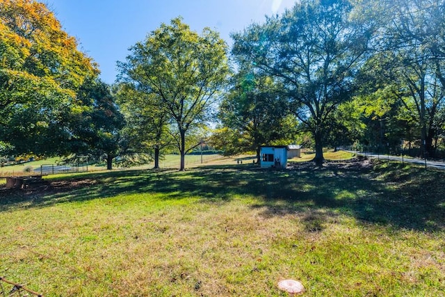 view of yard featuring a rural view and a shed