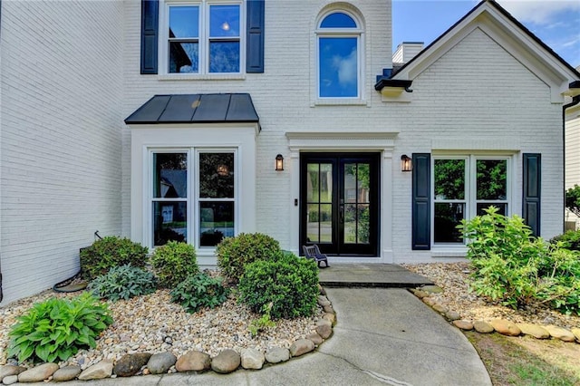 9440 Knollcrest Blvd, Alpharetta, GA 30022 - property entrance featuring brick siding, a standing seam roof, french doors, and metal roof
