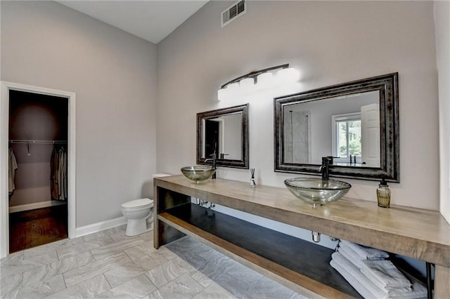9440 Knollcrest Blvd, Alpharetta, GA 30022 - full bath featuring toilet, a walk in closet, double vanity, baseboards, and marble look tiles