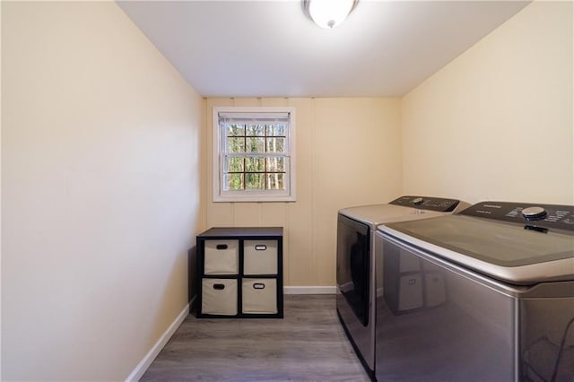 clothes washing area featuring independent washer and dryer and wood-type flooring