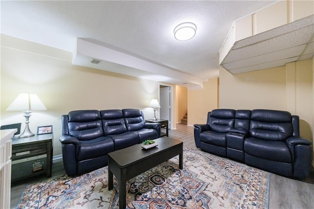 living room with hardwood / wood-style floors and a textured ceiling