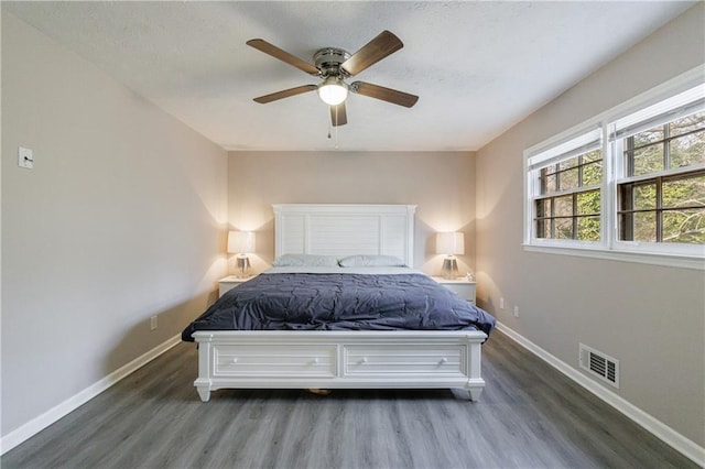 bedroom with dark hardwood / wood-style flooring and ceiling fan