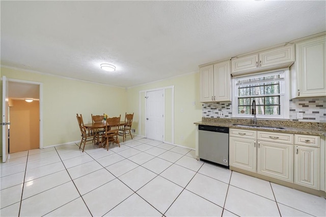 kitchen featuring sink, dishwasher, tasteful backsplash, cream cabinets, and light tile patterned flooring