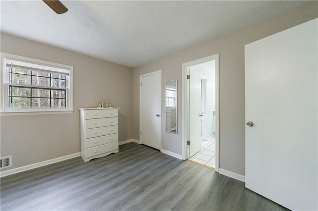 unfurnished bedroom featuring multiple windows and hardwood / wood-style flooring