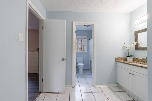 bathroom with vanity, tile patterned floors, a textured ceiling, and toilet