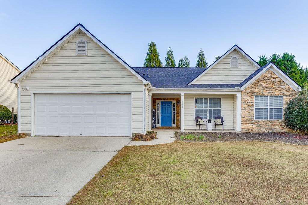 ranch-style home featuring a garage and a front lawn