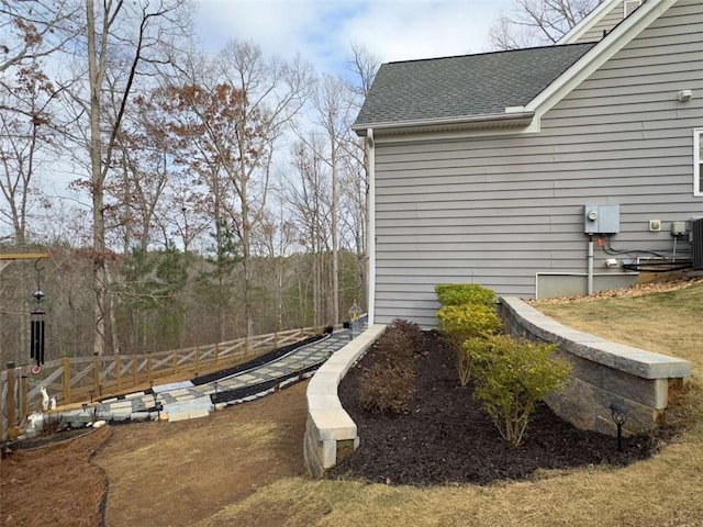 view of yard featuring fence and central AC unit