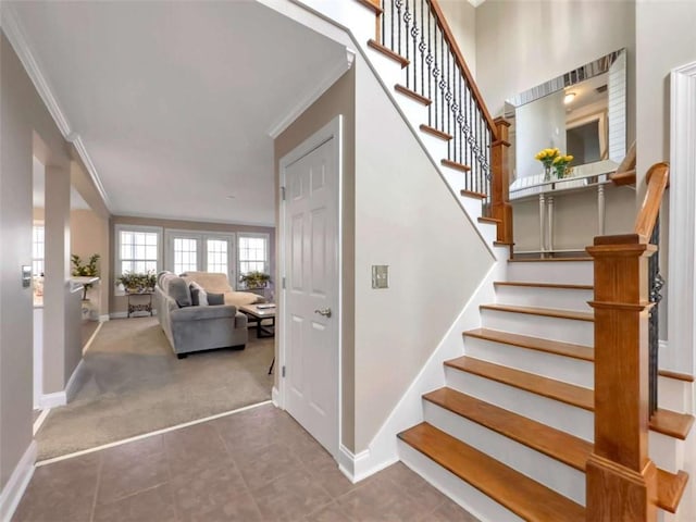 stairs featuring ornamental molding, tile patterned flooring, carpet flooring, and baseboards