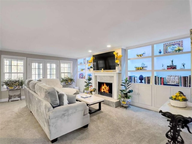 carpeted living room with built in shelves, a tiled fireplace, and recessed lighting