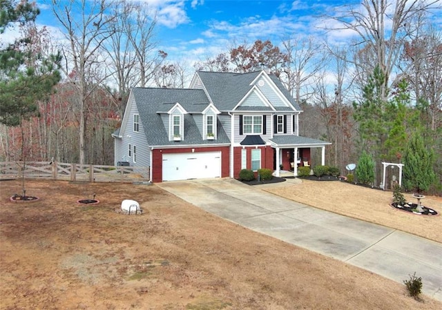 view of front facade with roof with shingles, fence, driveway, and an attached garage