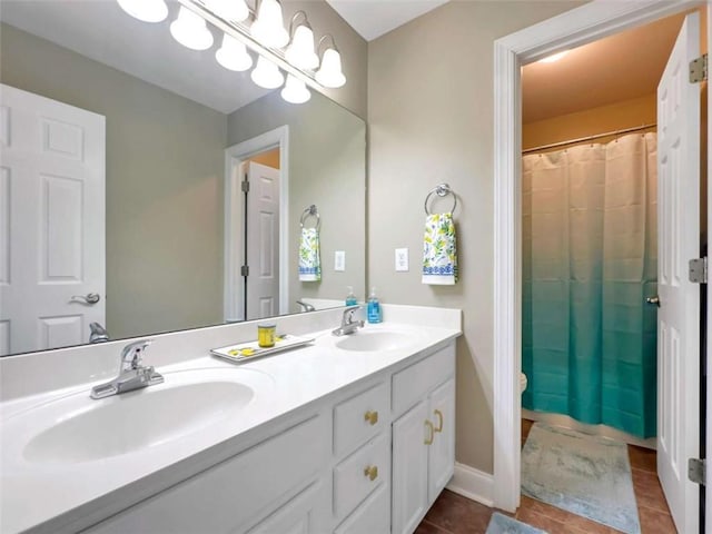 bathroom featuring double vanity, tile patterned flooring, baseboards, and a sink