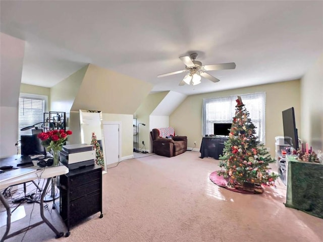 interior space with carpet, baseboards, vaulted ceiling, and a ceiling fan