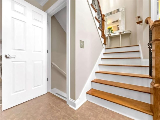 staircase featuring tile patterned flooring and baseboards