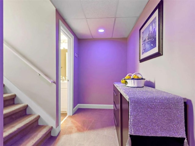 interior space featuring a drop ceiling, connected bathroom, recessed lighting, carpet flooring, and baseboards