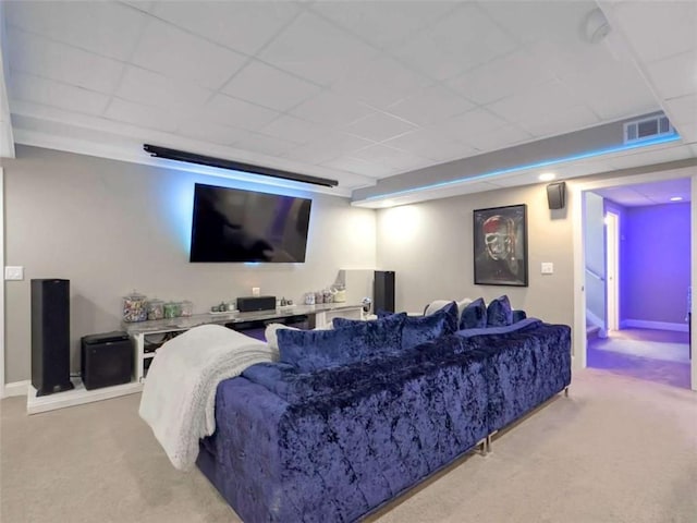 home theater featuring light carpet, a paneled ceiling, and visible vents