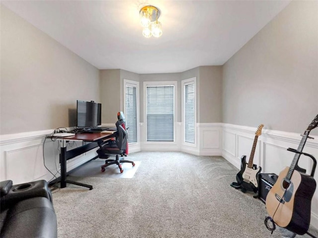 carpeted office space with wainscoting and a decorative wall