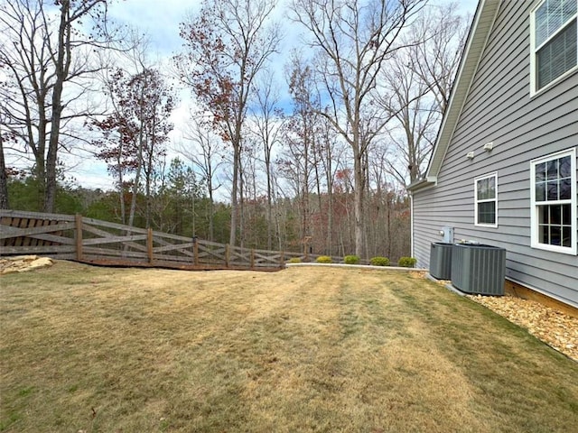 view of yard with central AC unit and fence