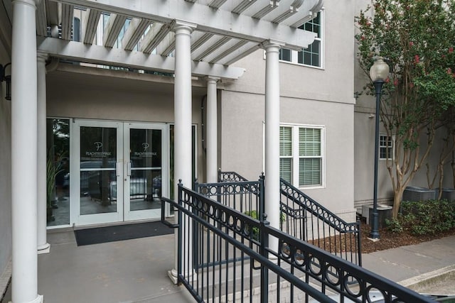 1075 Peachtree Walk NE Unit A519, Atlanta, GA 30309 - view of exterior entry featuring stucco siding, a pergola, a patio area, and french doors
