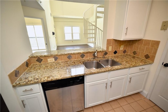 1075 Peachtree Walk NE Unit A519, Atlanta, GA 30309 - kitchen with light stone counters, stainless steel dishwasher, white cabinetry, and a sink