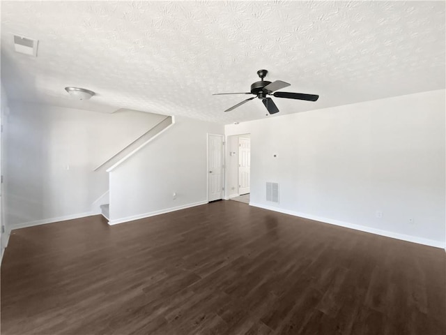 unfurnished living room featuring dark wood-style flooring, visible vents, stairway, and baseboards