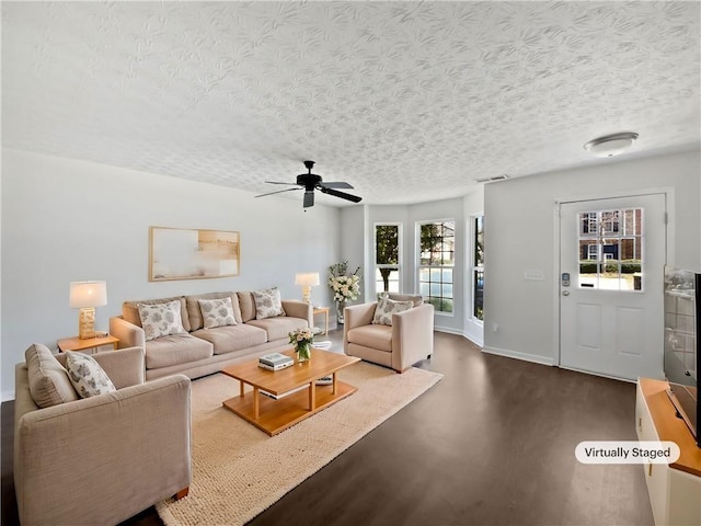 living room with visible vents, baseboards, dark wood-style flooring, and a textured ceiling