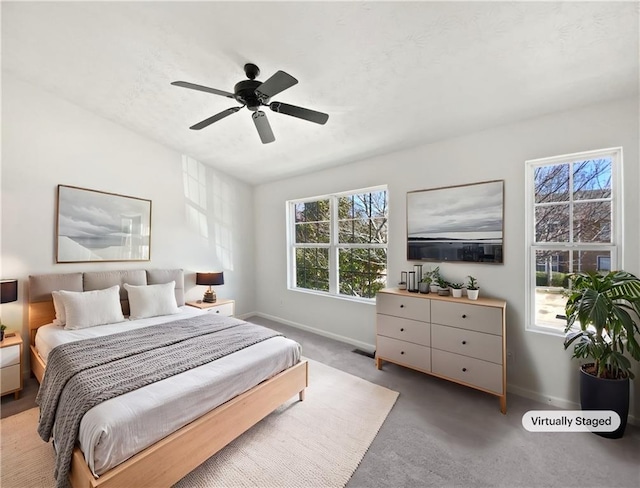 carpeted bedroom with a ceiling fan, visible vents, and baseboards