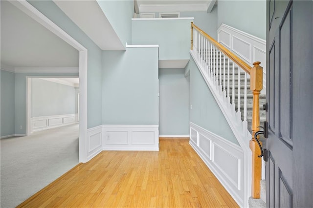 staircase featuring crown molding and carpet floors