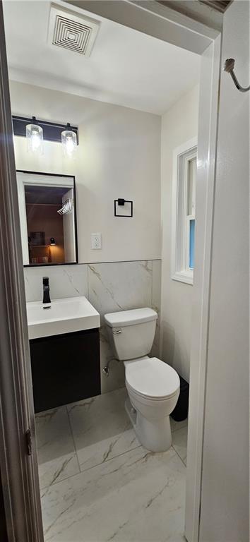 2511 Oak Ave, Tucker, GA 30084 - bathroom with vanity, marble look tiles, and toilet