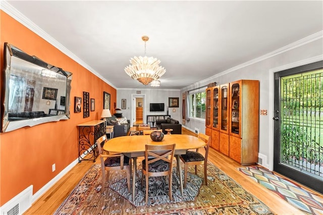 2511 Oak Ave, Tucker, GA 30084 - dining area featuring light wood-type flooring, ornamental molding, a chandelier, and baseboards
