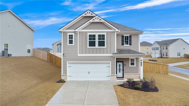 craftsman inspired home with fence, driveway, an attached garage, board and batten siding, and brick siding