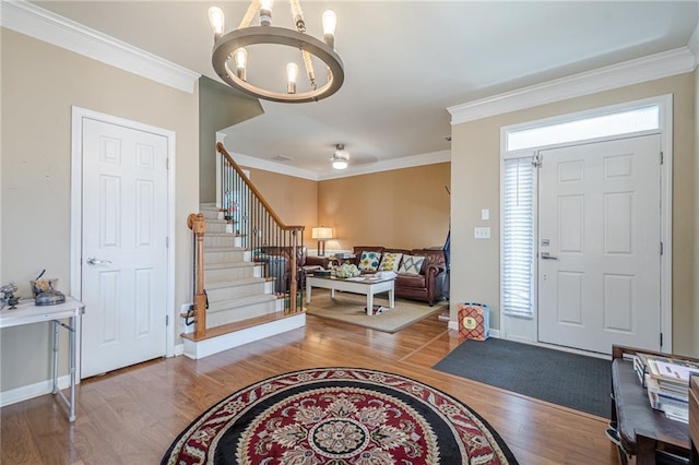 13943 Sunfish Bnd, Alpharetta, GA 30004 - entrance foyer featuring crown molding, stairs, wood finished floors, and a notable chandelier