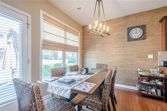 13943 Sunfish Bnd, Alpharetta, GA 30004 - dining space featuring a chandelier, an accent wall, baseboards, wallpapered walls, and visible vents