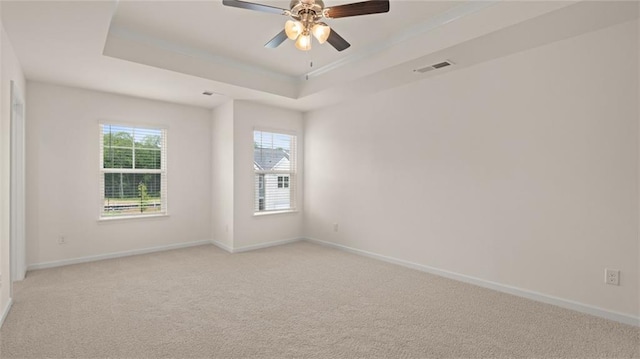 unfurnished room with baseboards, a raised ceiling, visible vents, and light colored carpet