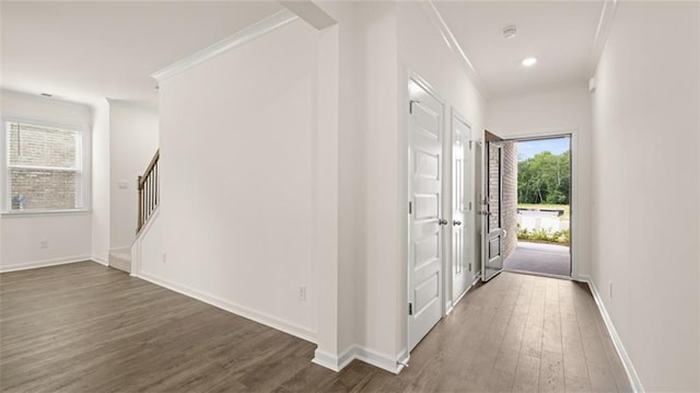 entrance foyer featuring stairs, ornamental molding, wood finished floors, and baseboards