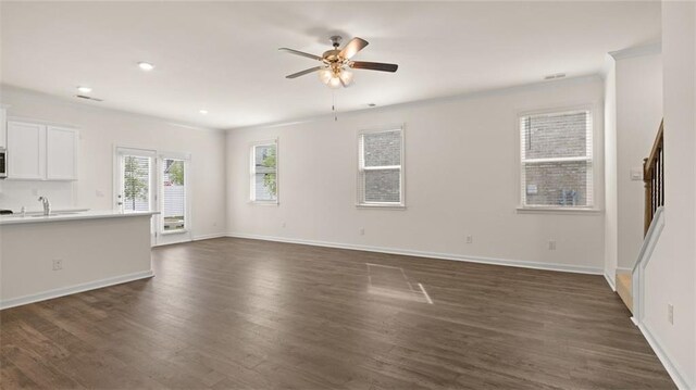 unfurnished living room with baseboards, a ceiling fan, dark wood-style floors, ornamental molding, and recessed lighting