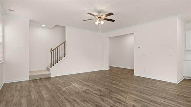 empty room featuring stairs, wood finished floors, and crown molding