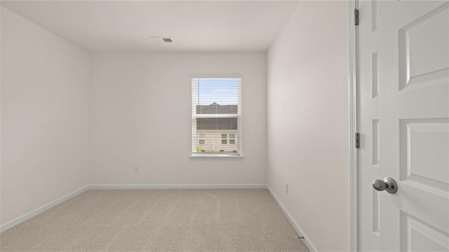 unfurnished room with light colored carpet and baseboards