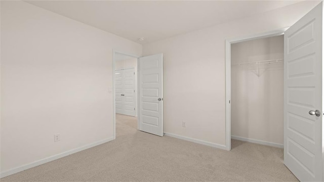 unfurnished bedroom featuring carpet, baseboards, and a closet