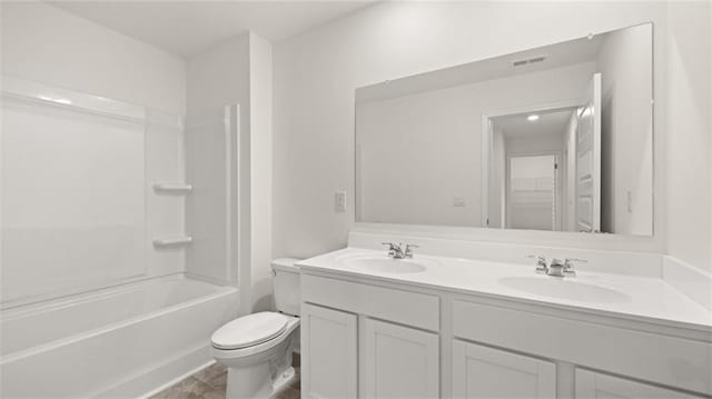 bathroom featuring toilet, double vanity, visible vents, and a sink