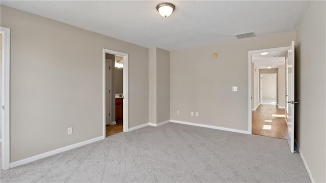 unfurnished bedroom with connected bathroom and light colored carpet