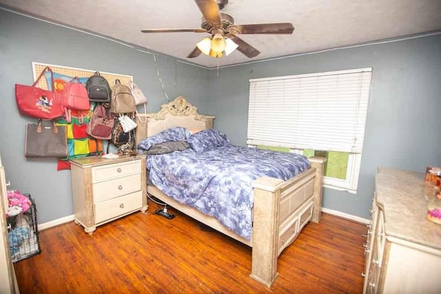 bedroom with dark hardwood / wood-style flooring and ceiling fan