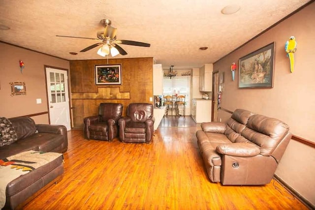 living room with light hardwood / wood-style flooring, ceiling fan, and a textured ceiling