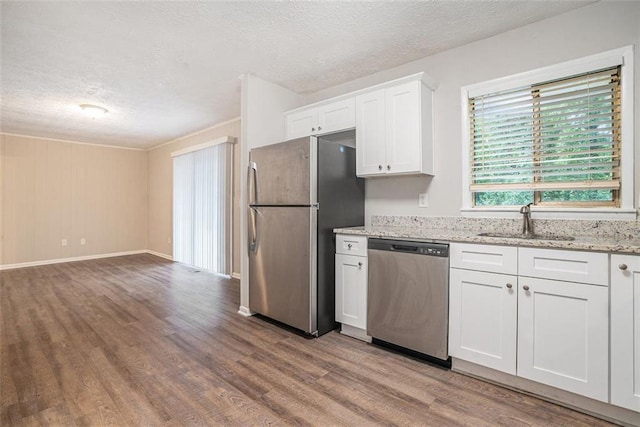 4442 Cedar Ridge Trl, Stone Mountain, GA 30083 - kitchen with stainless steel appliances, wood finished floors, a textured ceiling, white cabinetry, and light stone counters